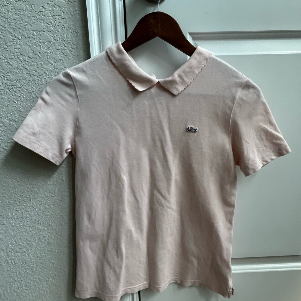 Lacoste women's pink short-sleeve polo shirt with a scalloped collar.